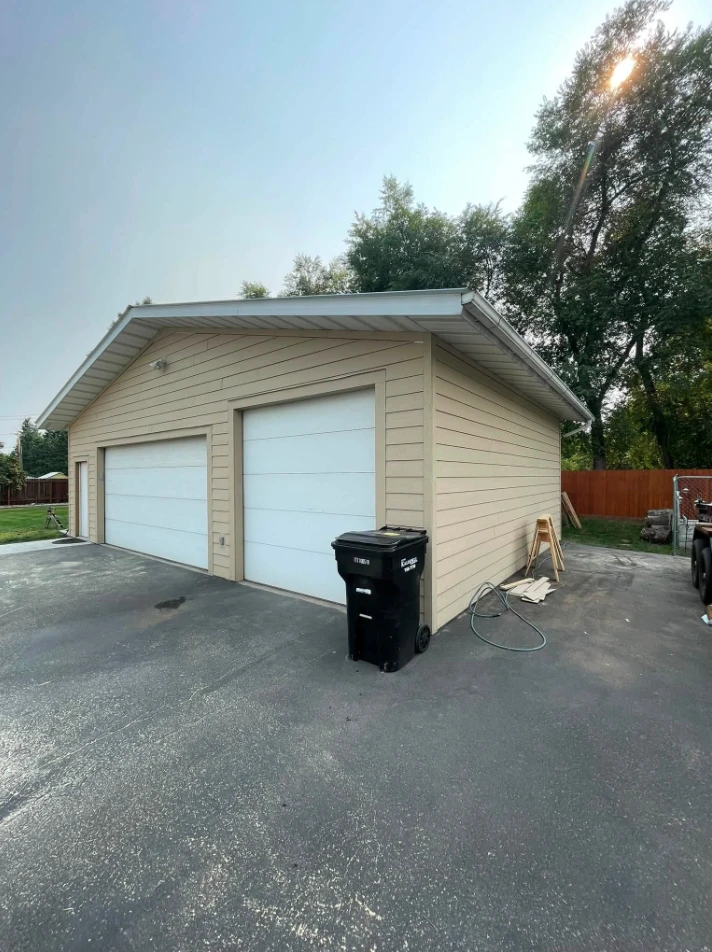 Completed two-stall garage with lap siding and finished doors